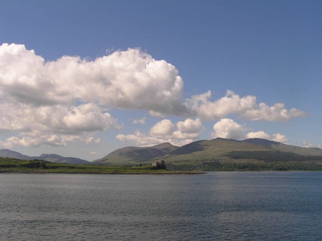 Een prachtig schots vergezicht: heuvels, wolkenlucht, blauwe zee en kasteel. Dit is the Isle of Mull