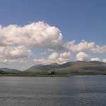 Een prachtig schots vergezicht: heuvels, wolkenlucht, blauwe zee en kasteel. Dit is the Isle of Mull
